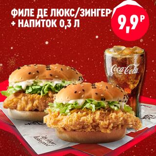 Два бургера с хрустящей курицей — Филе де люкс и Зингер — стоят рядом с высоким стаканом газированного напитка со льдом