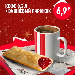 Кружка кофе объёмом 0.3 литра и вишнёвый пирожок с хрустящей корочкой и видимой начинкой, лежащие рядом в наборе