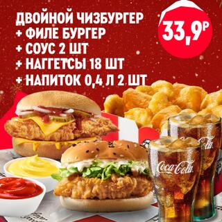 Два куриных бургера, порция наггетсов, два вида соусов и два стакана газированного напитка собраны вместе в большом наборе