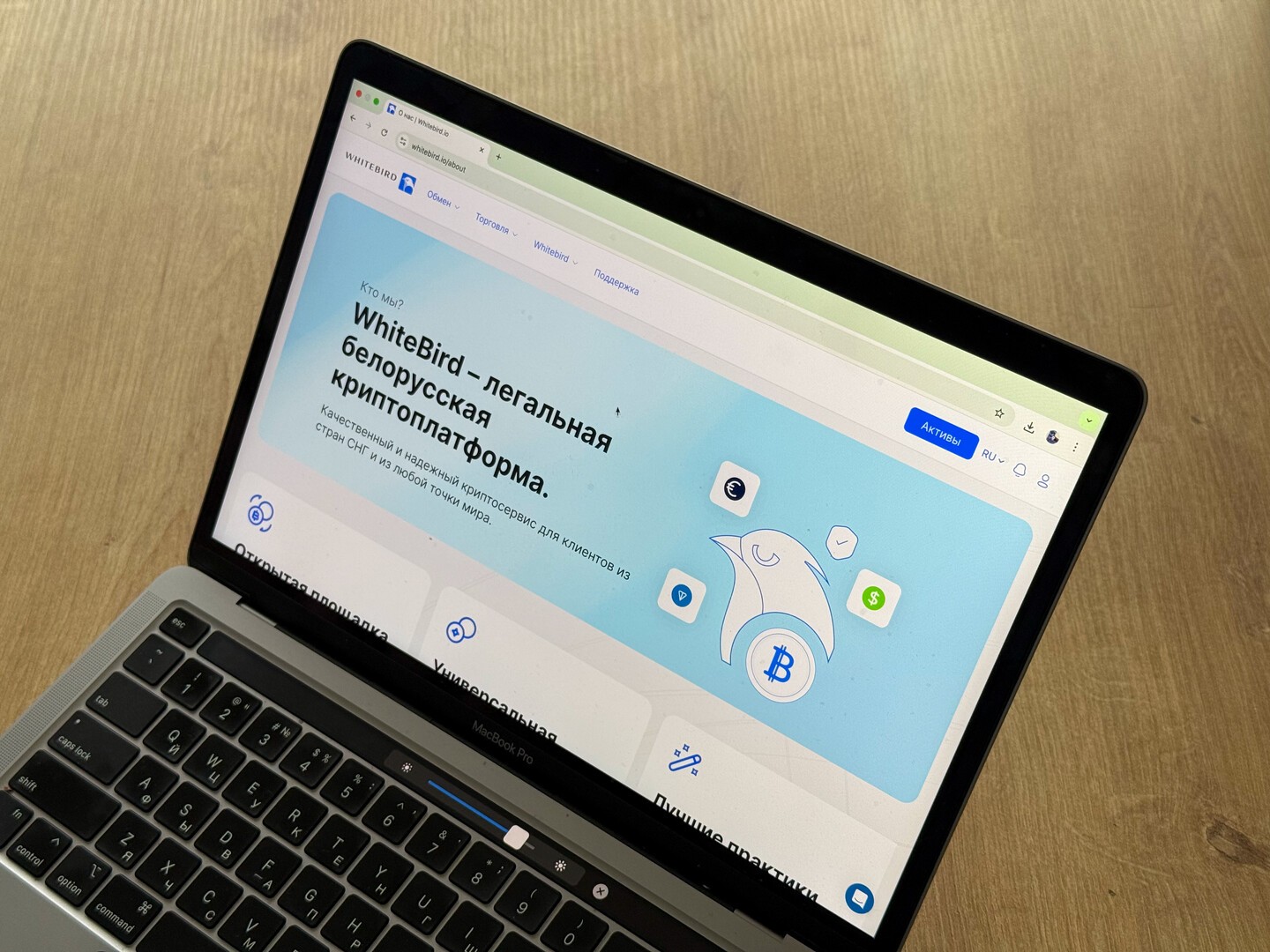 Ноутбук с открытой страницей криптоплатформы Whitebird, показывающей раздел о легальном обмене цифровых активов